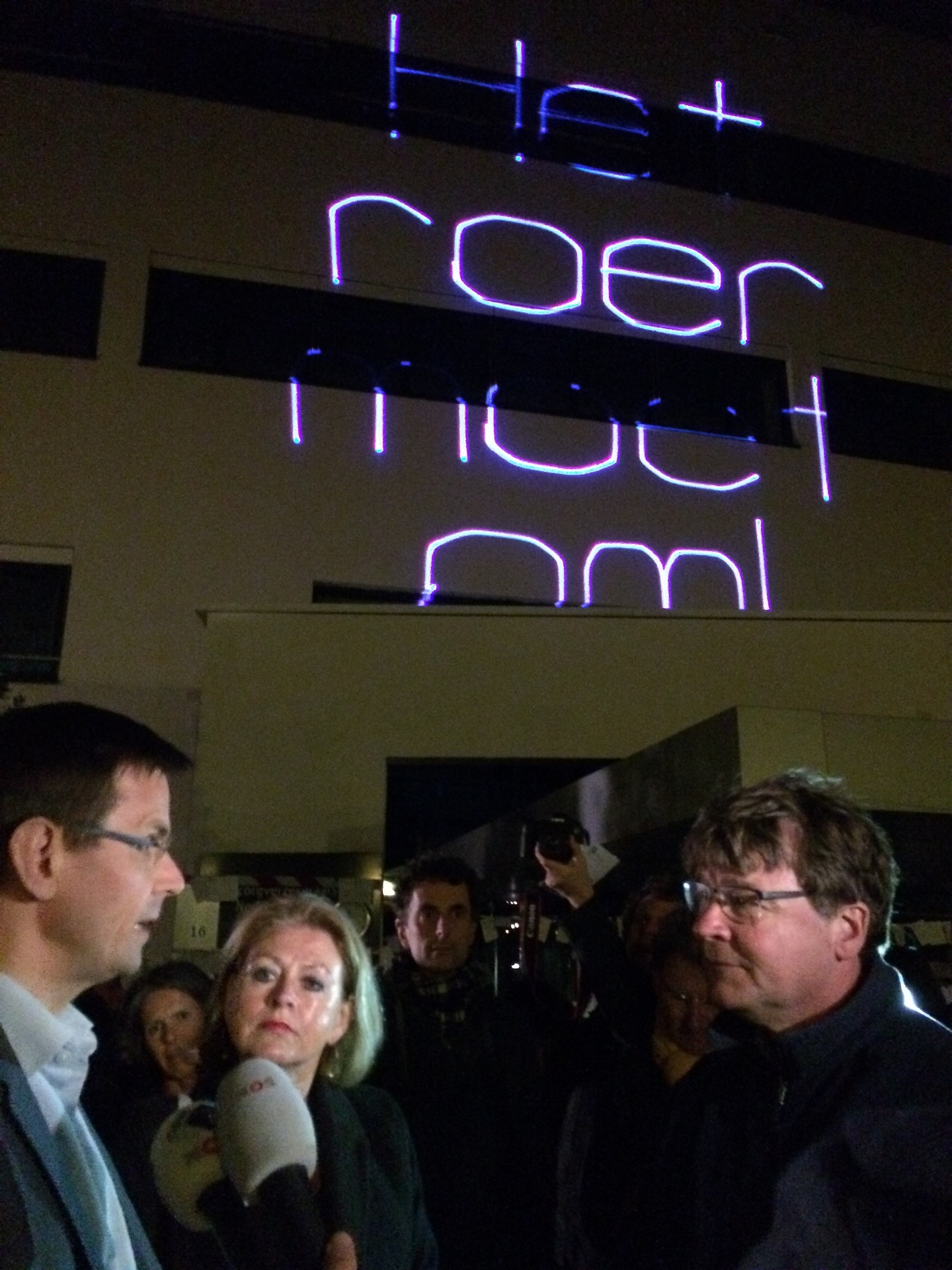 Laserprojectie 'Het roer moet om' op het hoofdkantoor van Zorgverzekeraars Nederland, met op de voorgrond een interview met voorzitter André Rouvoet.